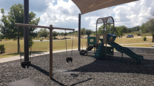 Swings and slides of the playground at the City Of Bee Cave Central Park Bee Cave, TX